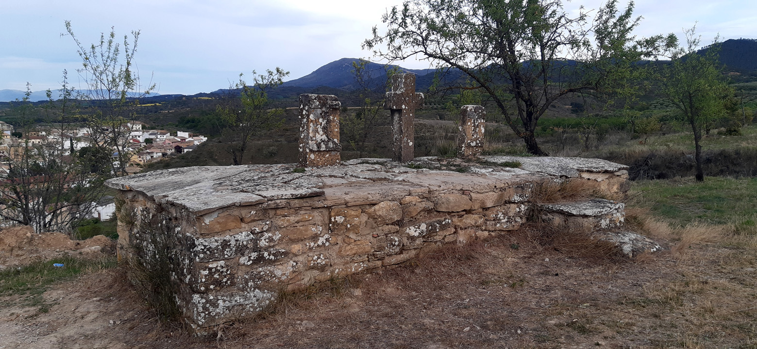 Cruces de piedra y al fondo el pueblo